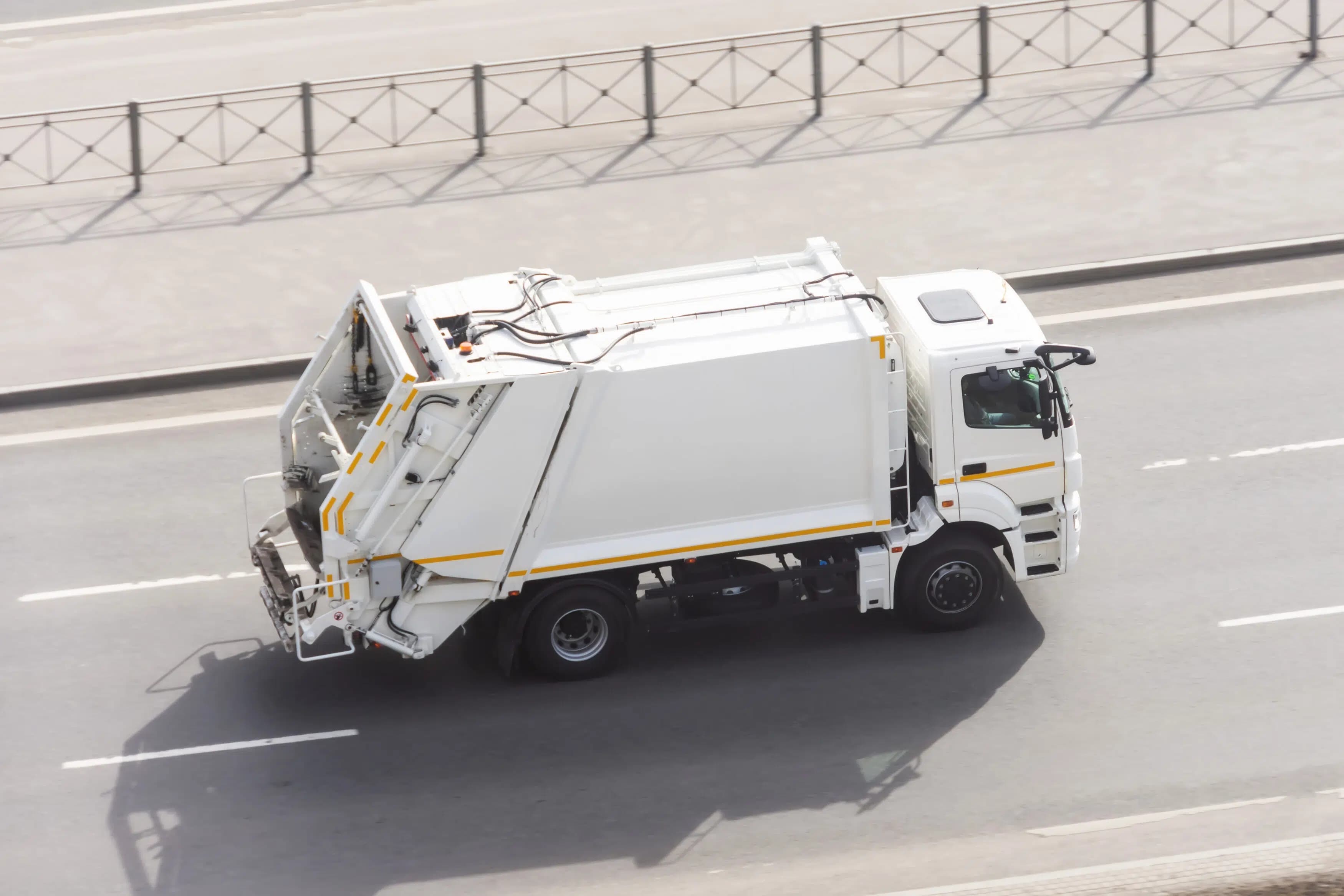 Recycling truck rides on the road in the city.